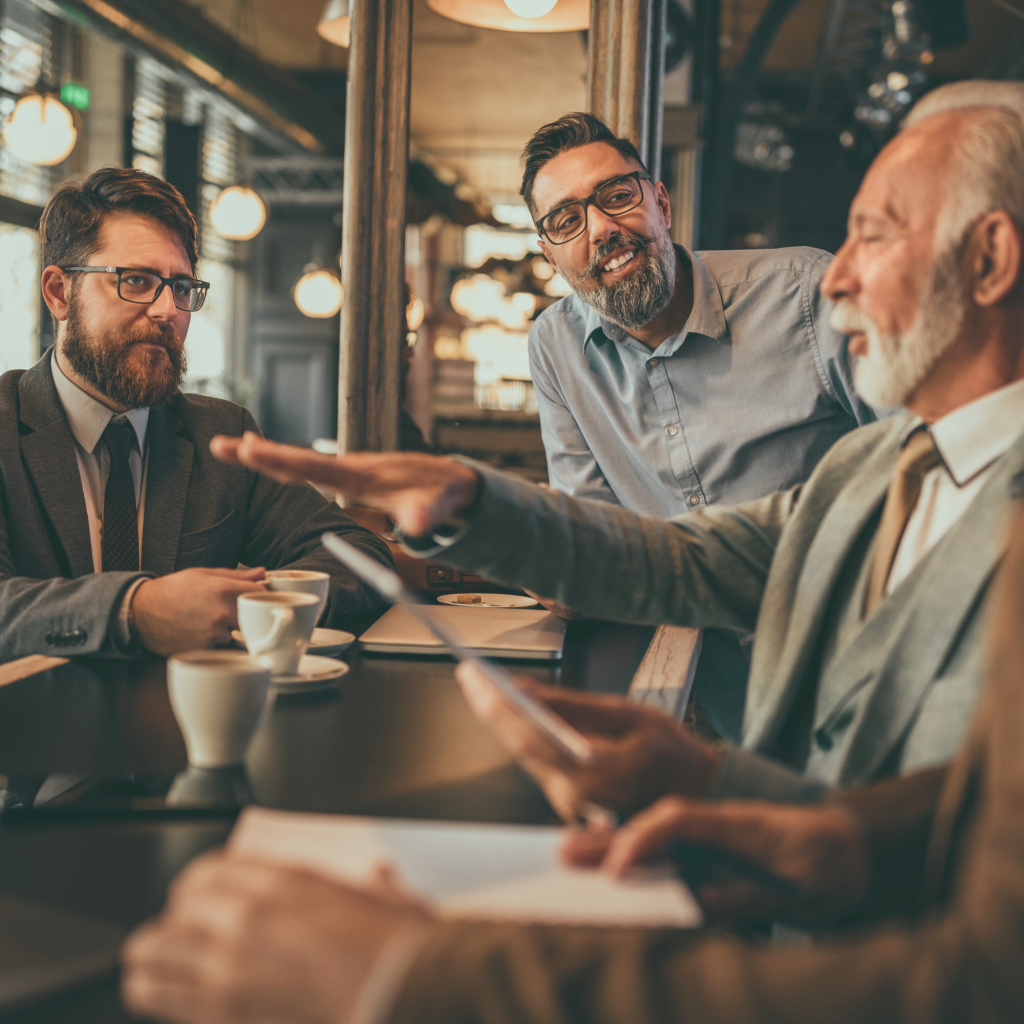 A group of professionals having a discussion in a cozy setting, sharing ideas and strategies over coffee.