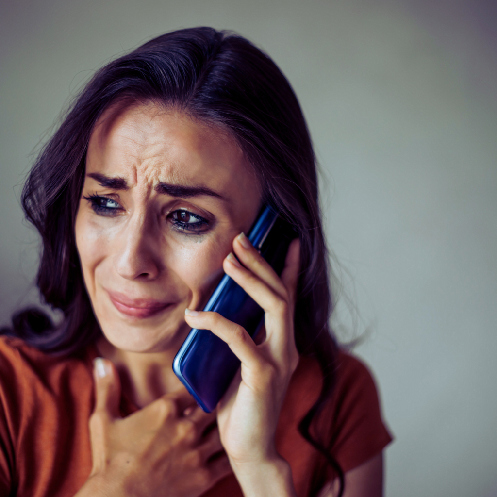 A distressed woman on a phone call, appearing to be upset and emotional.